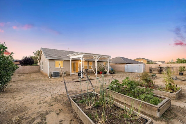 7150 Lyric Ave, Lancaster, CA 93536 - back of property at dusk with a garden, central air condition unit, a fenced backyard, a pergola, and a patio area