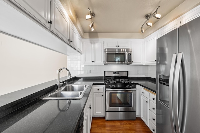 kitchen with a sink, white cabinets, appliances with stainless steel finishes, and tasteful backsplash
