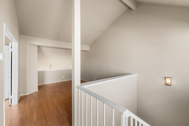 corridor with an upstairs landing, vaulted ceiling with beams, and wood finished floors