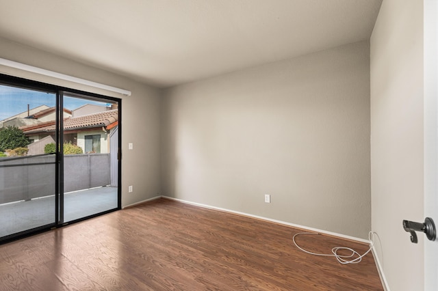 unfurnished room with baseboards and wood finished floors
