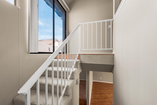 staircase with baseboards and wood finished floors
