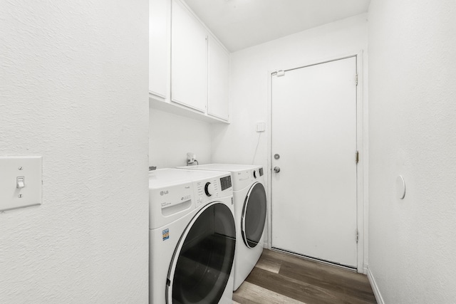 clothes washing area featuring light hardwood / wood-style floors, cabinets, and washing machine and clothes dryer