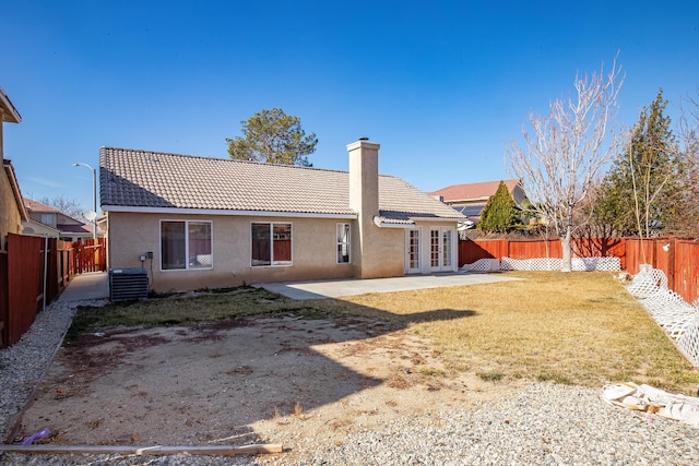 back of property featuring a patio area, french doors, central air condition unit, and a lawn