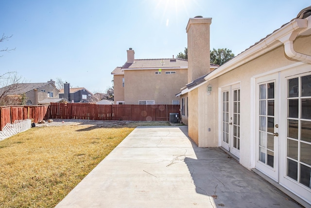 view of yard featuring french doors, a patio area, and cooling unit