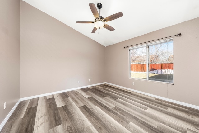 spare room featuring hardwood / wood-style floors, vaulted ceiling, and ceiling fan