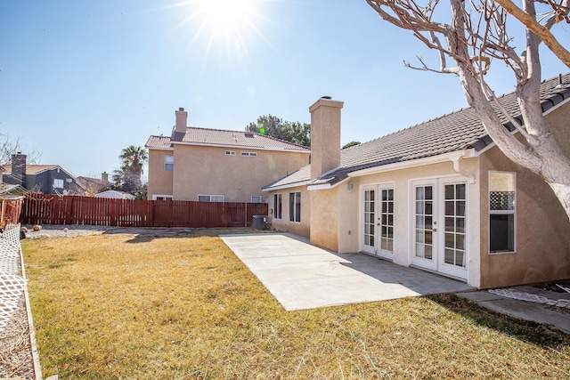 back of property with french doors, a yard, a patio, and cooling unit