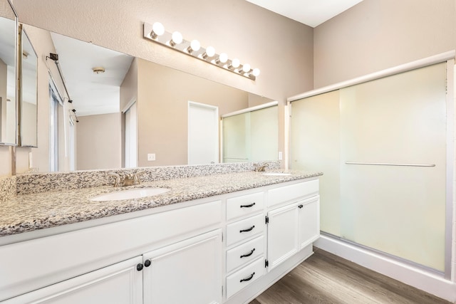 bathroom with vanity, wood-type flooring, and a shower with door