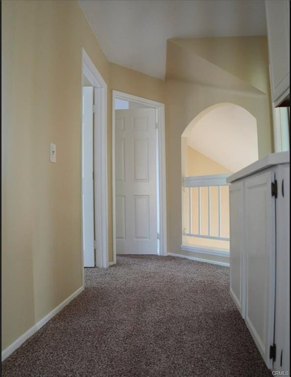 hall featuring baseboards and carpet