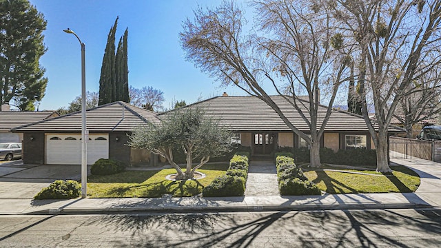 ranch-style house featuring a front lawn and a garage