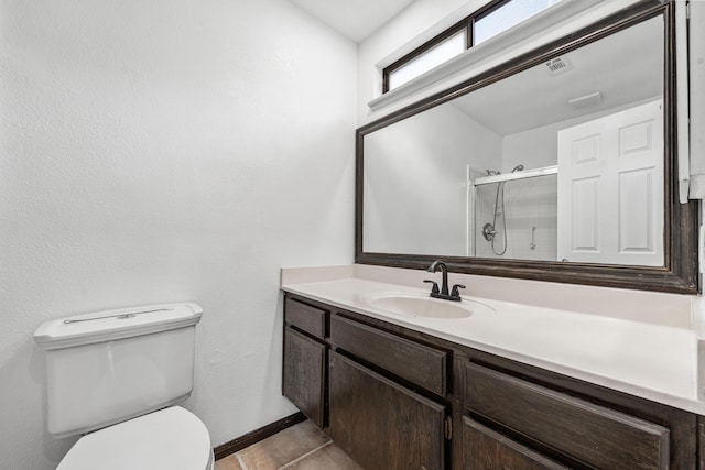 bathroom featuring vanity, toilet, tile patterned floors, baseboards, and a shower stall