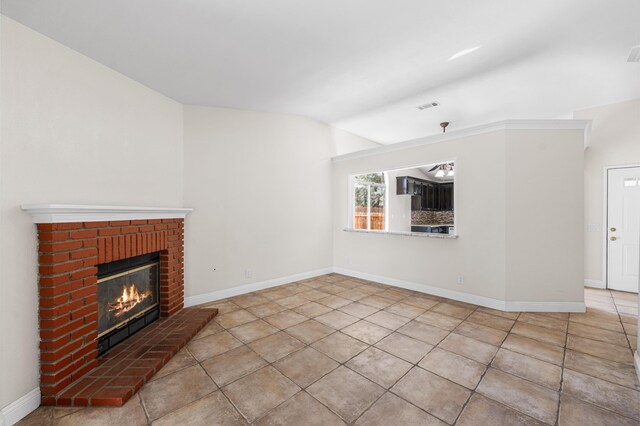unfurnished living room with visible vents, a brick fireplace, tile patterned floors, baseboards, and lofted ceiling