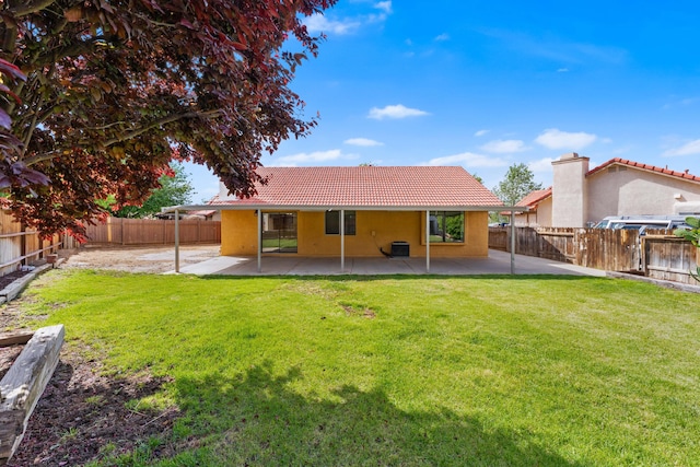 back of house featuring a patio, a lawn, stucco siding, and a tiled roof