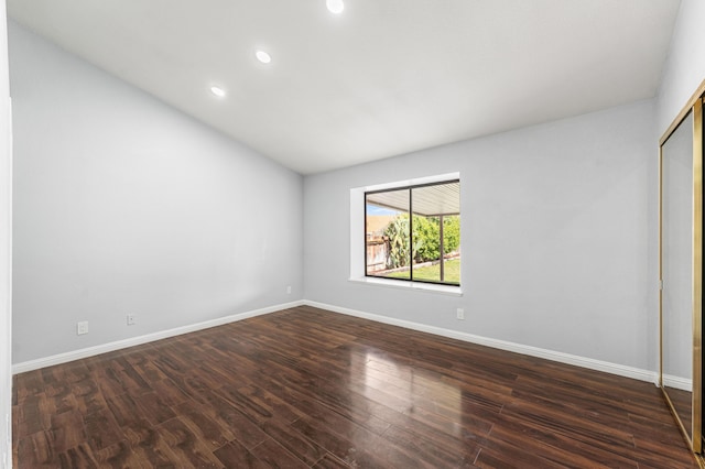 unfurnished bedroom with baseboards, dark wood-style flooring, a closet, and recessed lighting