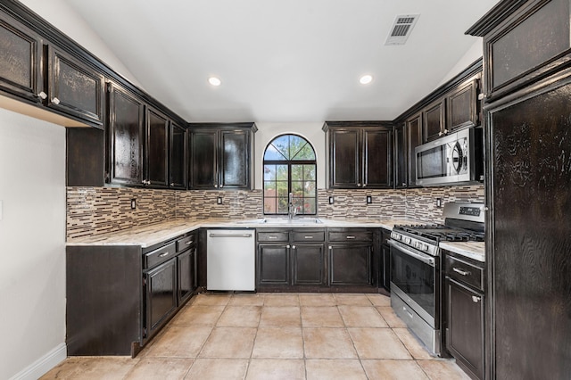kitchen featuring appliances with stainless steel finishes, decorative backsplash, a sink, and visible vents