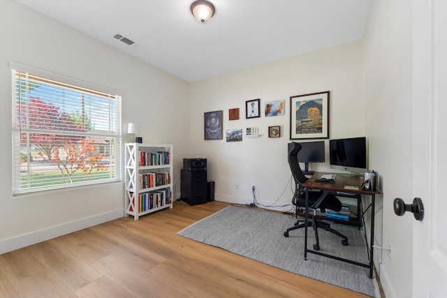 office area with baseboards, wood finished floors, and plenty of natural light