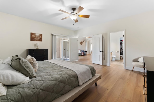 bedroom featuring light wood-type flooring, baseboards, a ceiling fan, and connected bathroom