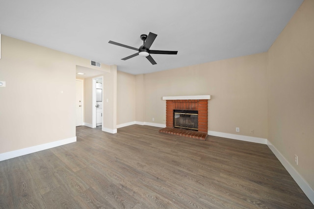 unfurnished living room featuring ceiling fan, a fireplace, and dark hardwood / wood-style floors