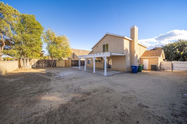 rear view of property with a pergola, central air condition unit, and a patio area