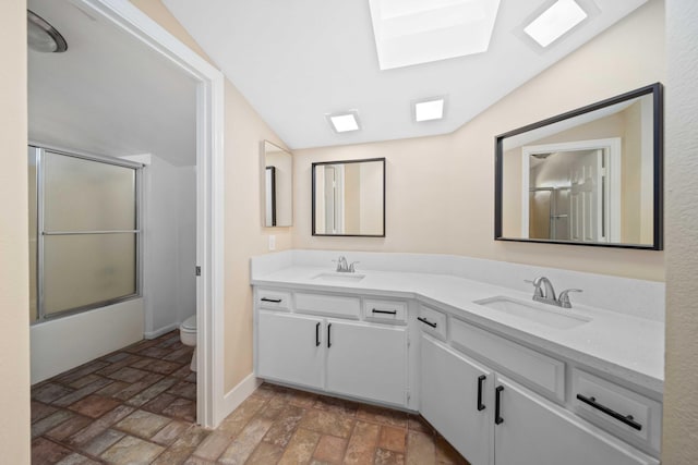 full bathroom with vaulted ceiling with skylight, vanity, enclosed tub / shower combo, and toilet