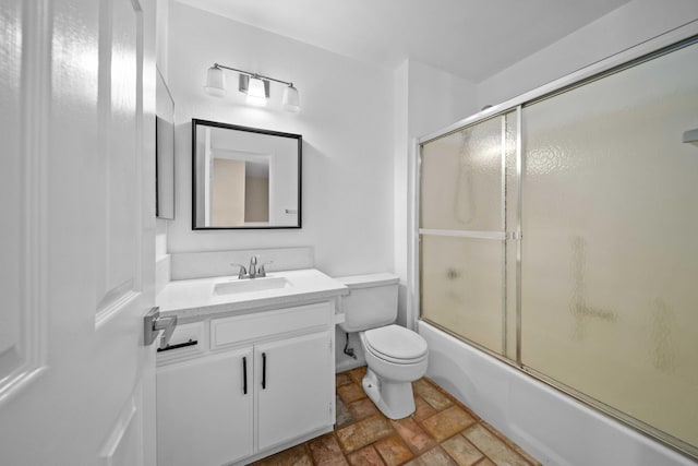 full bathroom featuring toilet, vanity, and combined bath / shower with glass door