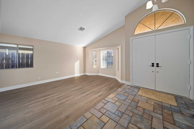 foyer entrance with hardwood / wood-style flooring and high vaulted ceiling