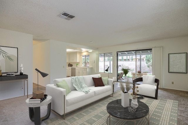 carpeted living area featuring a textured ceiling and visible vents