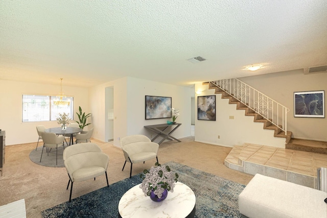 carpeted living area featuring stairs, visible vents, and a textured ceiling