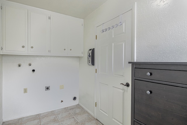 clothes washing area featuring gas dryer hookup, cabinet space, electric dryer hookup, and baseboards