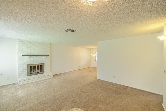 unfurnished living room with a brick fireplace, a textured ceiling, visible vents, and carpet flooring