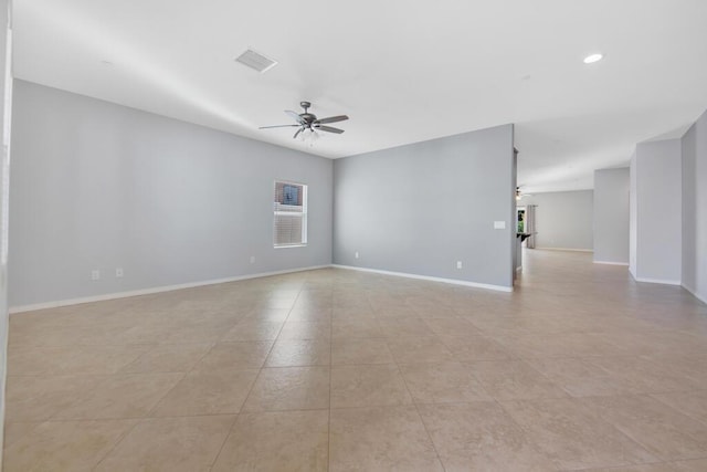 empty room with ceiling fan and light tile patterned floors