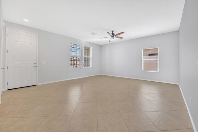 tiled spare room with ceiling fan