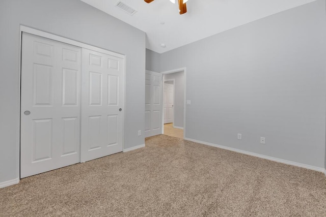 unfurnished bedroom with light carpet, a closet, and ceiling fan