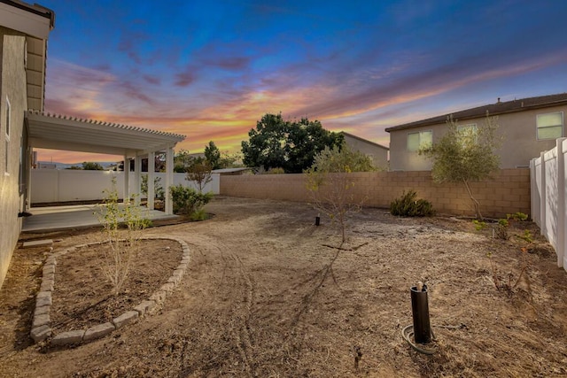 yard at dusk featuring a patio