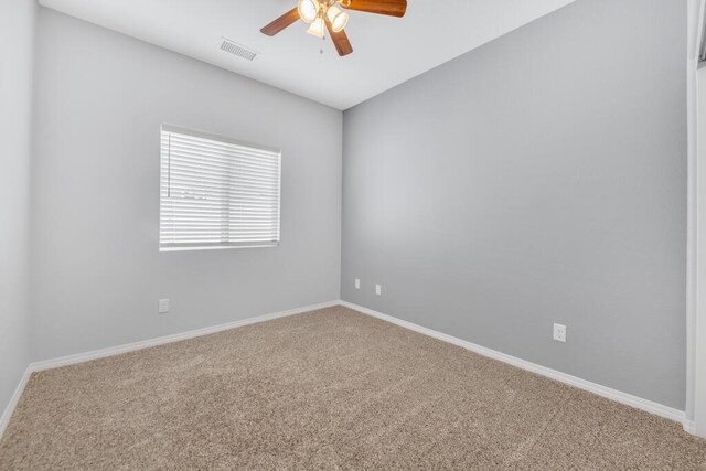 carpeted spare room featuring ceiling fan