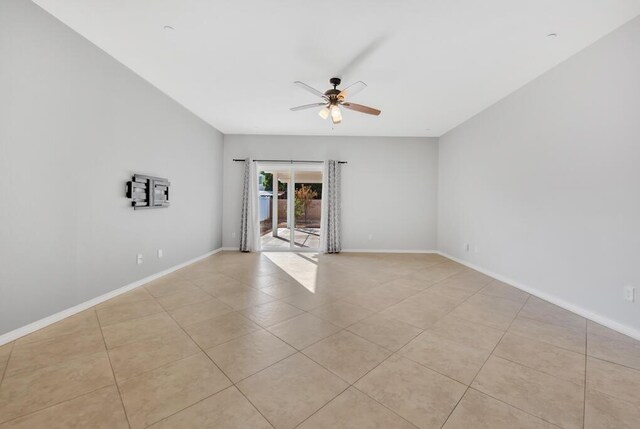 tiled spare room featuring ceiling fan