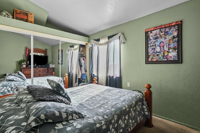 carpeted bedroom featuring lofted ceiling and a closet