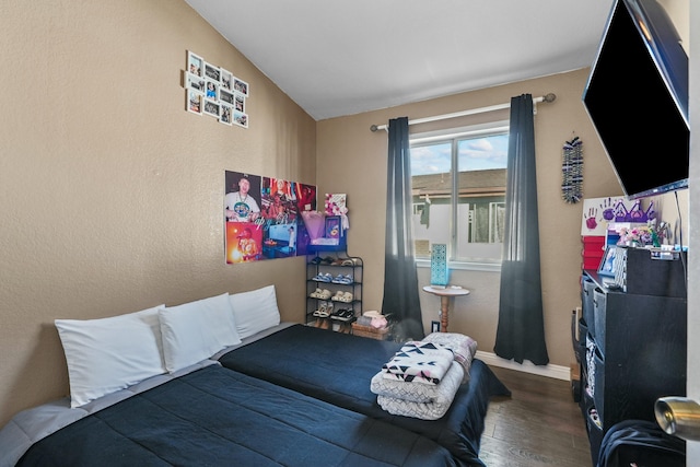 bedroom featuring dark wood-type flooring and vaulted ceiling