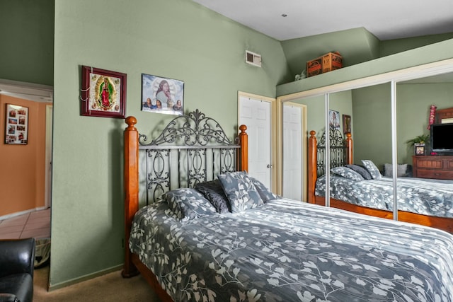 bedroom with carpet floors, a closet, and lofted ceiling