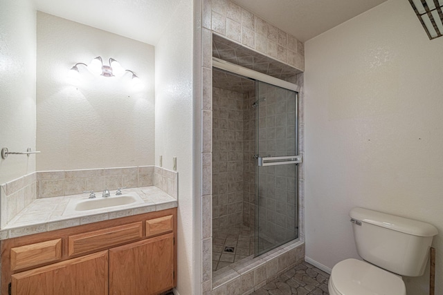 bathroom with a shower with door, vanity, and toilet