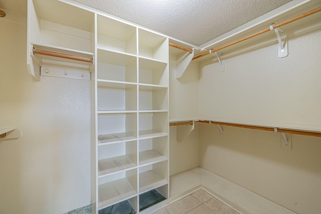 spacious closet with light tile patterned floors