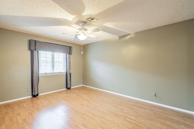 spare room featuring ceiling fan, light hardwood / wood-style floors, and a textured ceiling