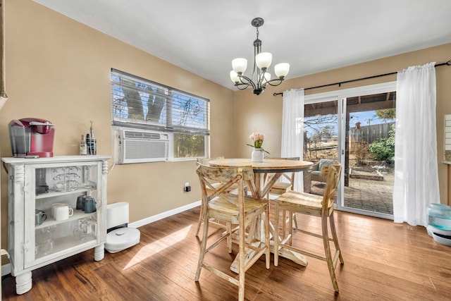 dining area with a notable chandelier, baseboards, a wealth of natural light, and wood finished floors