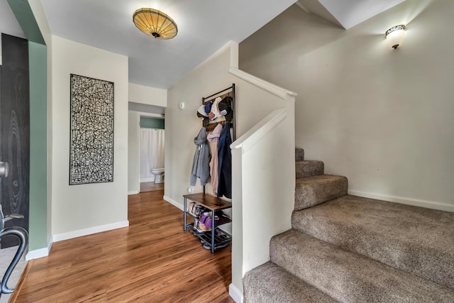 entrance foyer featuring stairs, baseboards, and wood finished floors