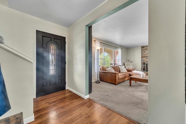 entrance foyer featuring a fireplace, baseboards, and wood finished floors