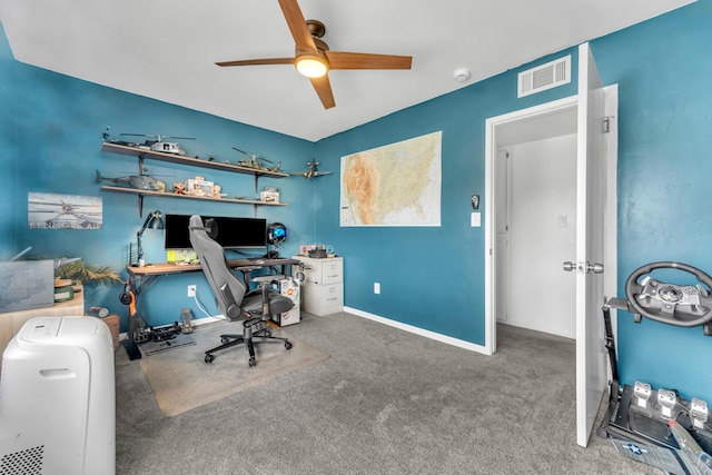 carpeted office with baseboards, visible vents, and a ceiling fan