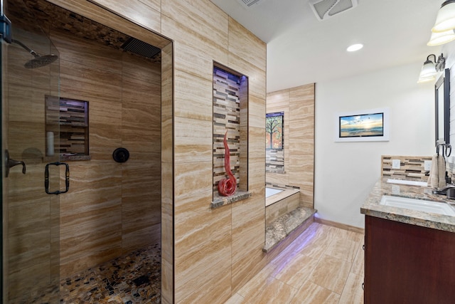 bathroom with vanity and independent shower and bath