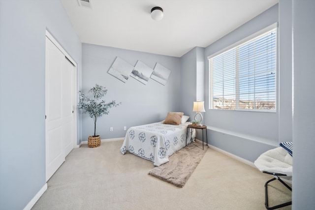 bedroom featuring light colored carpet and a closet