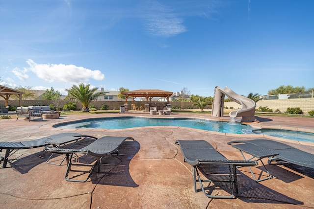 view of swimming pool featuring a gazebo, an in ground hot tub, a water slide, and a patio