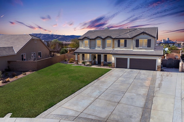 view of front property featuring a garage, a mountain view, and a yard