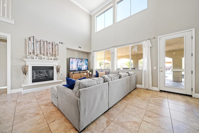 living room with ornamental molding, plenty of natural light, and light tile patterned floors